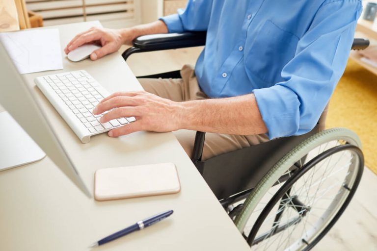 Mężczyzna pracujący przed komputerem pisze na klawiaturze