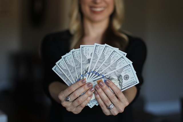 Kobieta trzymająca rozłożoną gotówkę w dłoniach