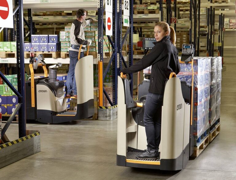 Pracownicy magazyny jeżdżą wózkami widłowymi elektrycznymi