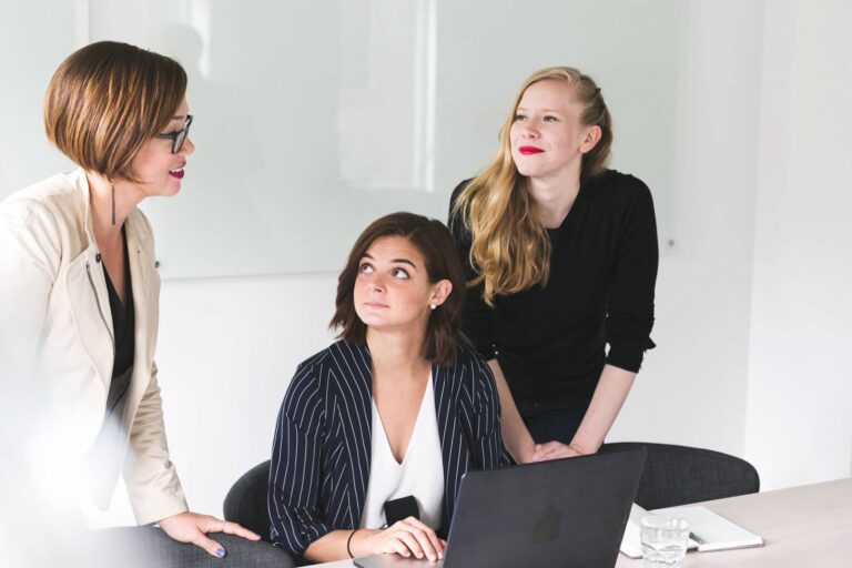 Trzy kobiety rozmawiają ze sobą w biurze